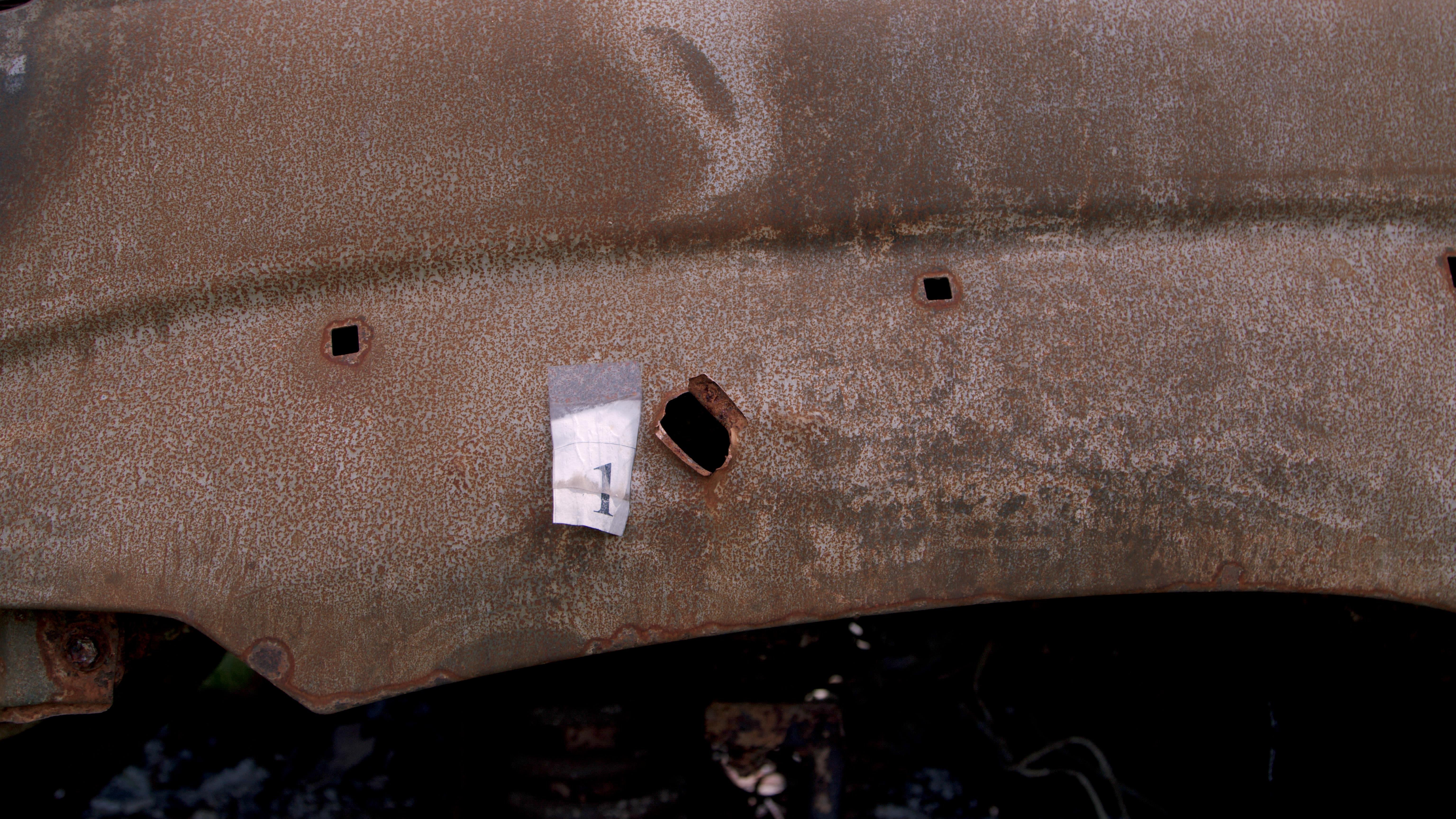 A mark of a bullet hit made by ballistics experts on a car shot up on the Zhytomyr highway. A car dump in the village of Dmytrivka, Kyiv region. Photo: DENOTAT documentary group, Roman Synchuk