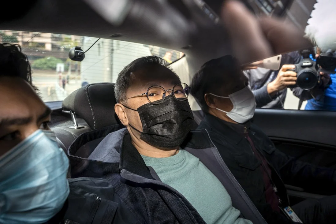 Заарештований сьогодні вранці опозиціонер Бенні Тай у центрі, двоє інших – спецслужбісти в цивільному: фото Bloomberg