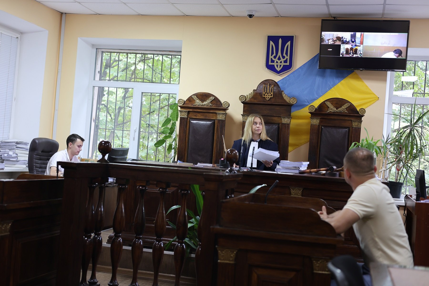 Щоб продемонструвати свою недовіру та неповагу до судді, обвинувачені часто повертаються до них спиною. Саме так зробив обвинувачений і цього разу під час відеоконференції. Фото авторки