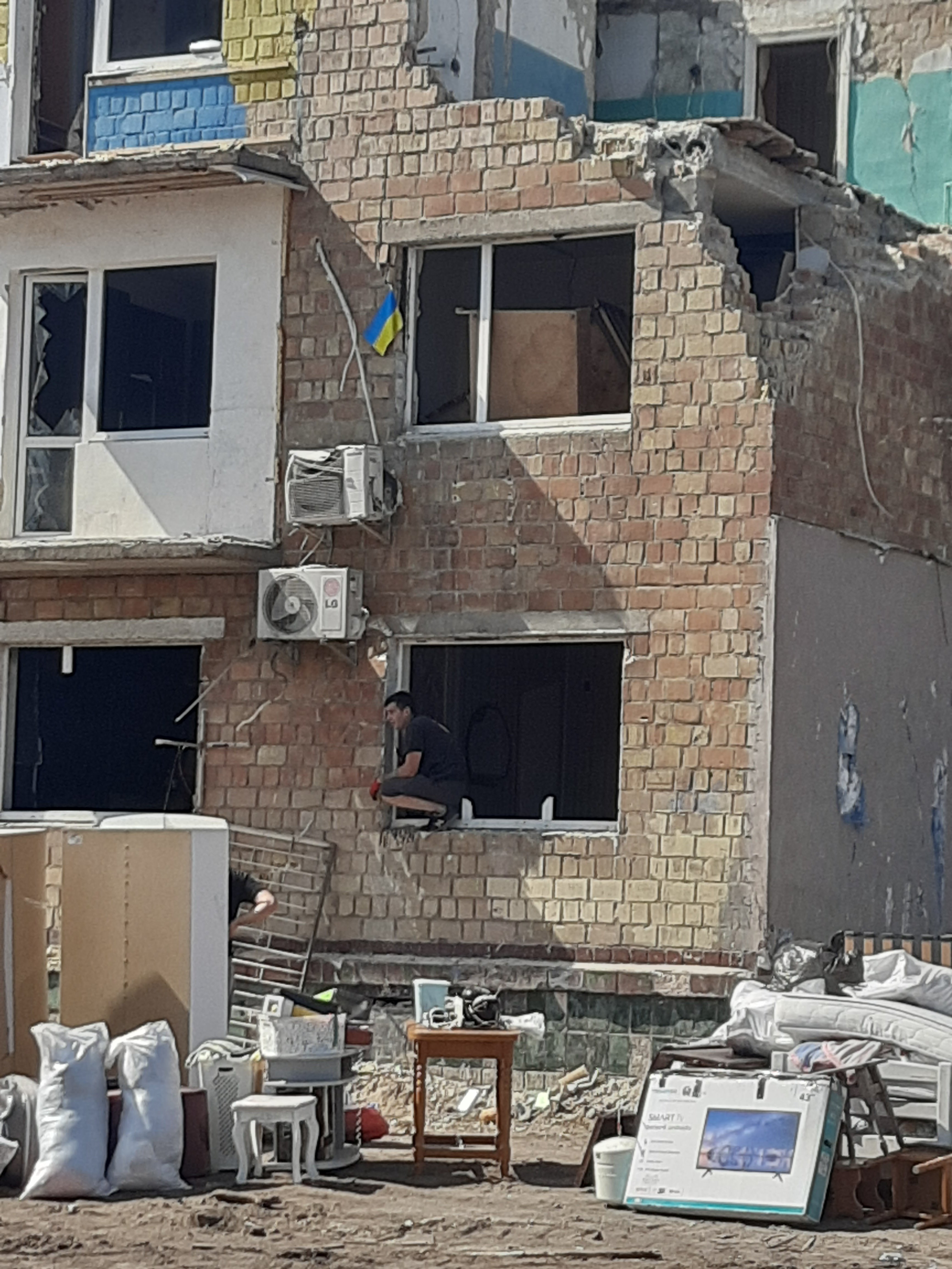 Мешканці будинку вивозять уціліле майно. Фото авторки