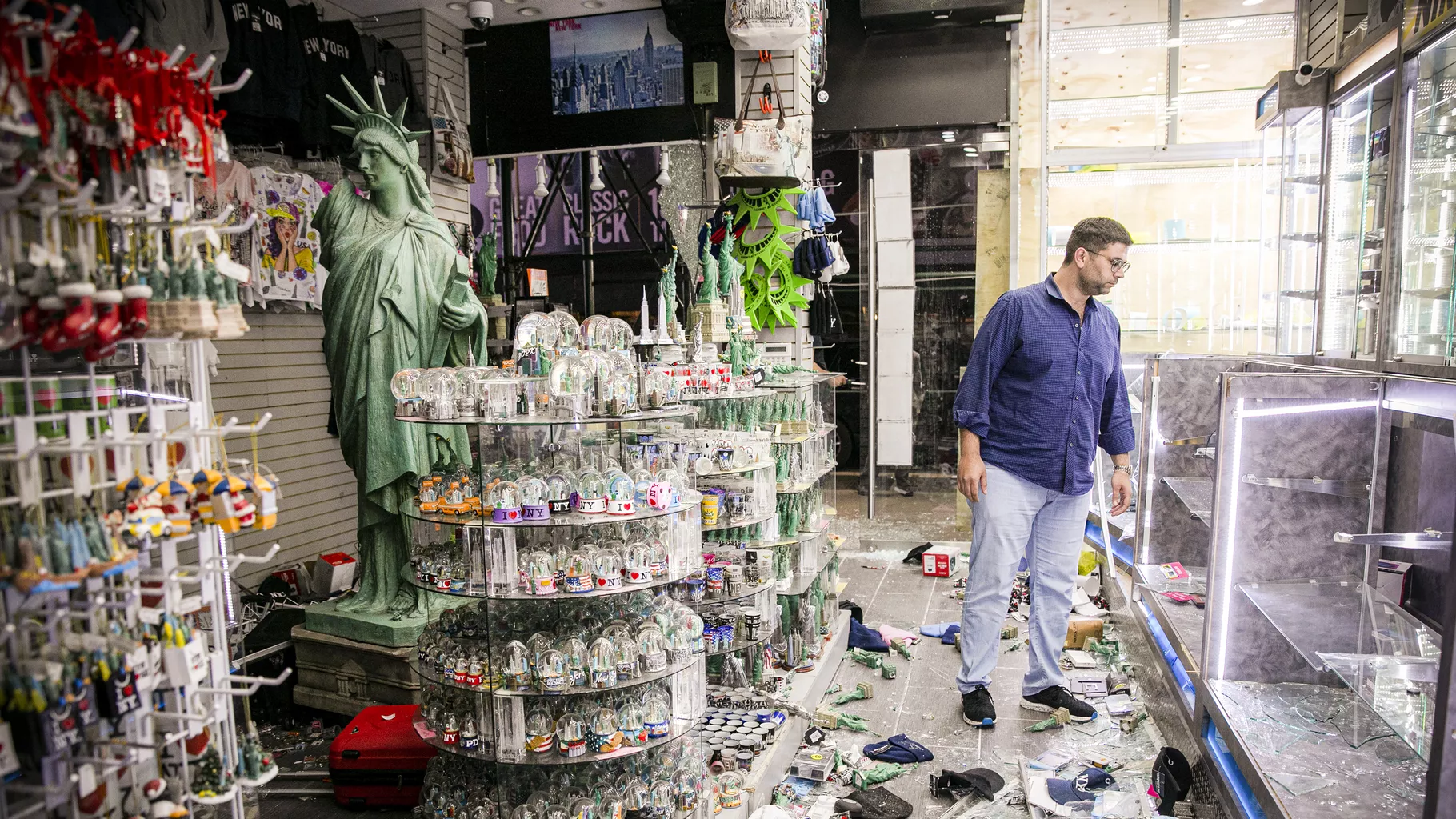 Власник крамниці на Таймс-сквер у Нью-Йорку оглядає завдану шкоду: фото Getty