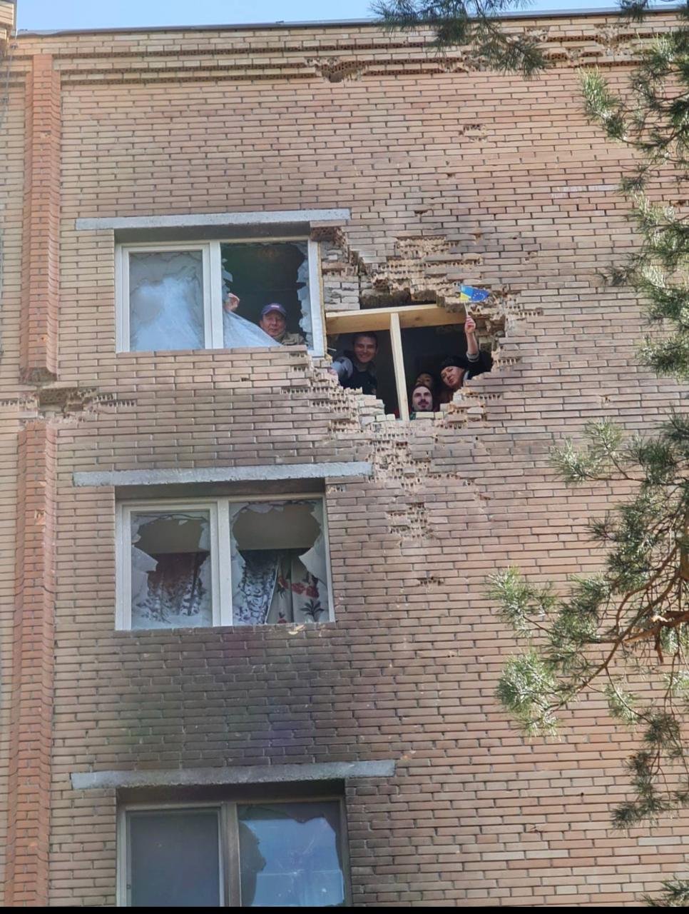 Мешканці будинку визирають надвір крізь дірку в стіні, яку намагаються залатати після повернення в Ірпінь. Фото надане співрозмовницею