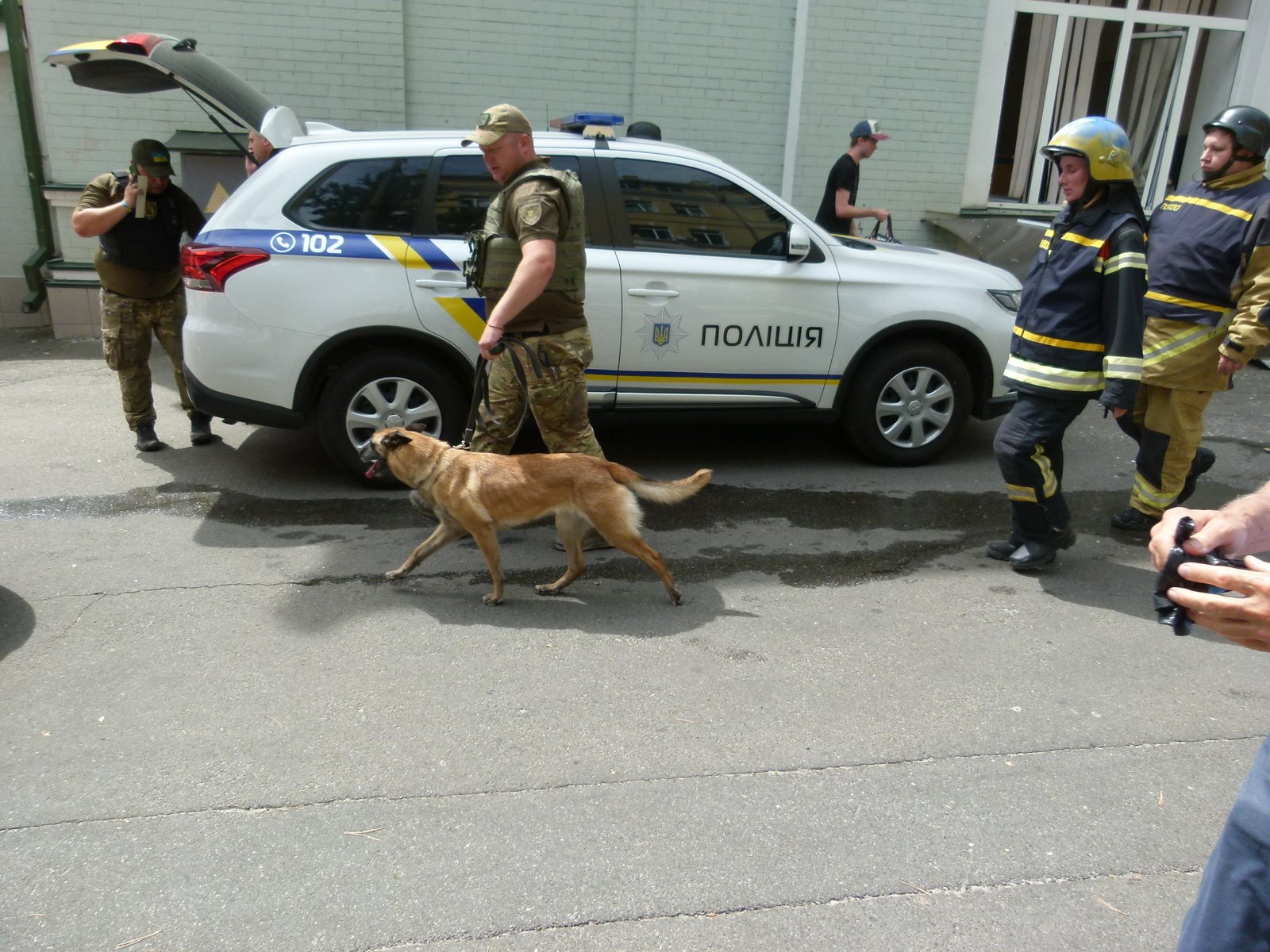 Кінолог із собакою приїхав шукати людей під завалами дитячої лікарні після російського ракетного удару в Києві. 8 липня 2024 року. Фото автора