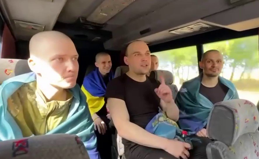 Serhii Taraniuk (far right) returns home with other prisoners. Screenshot from the video