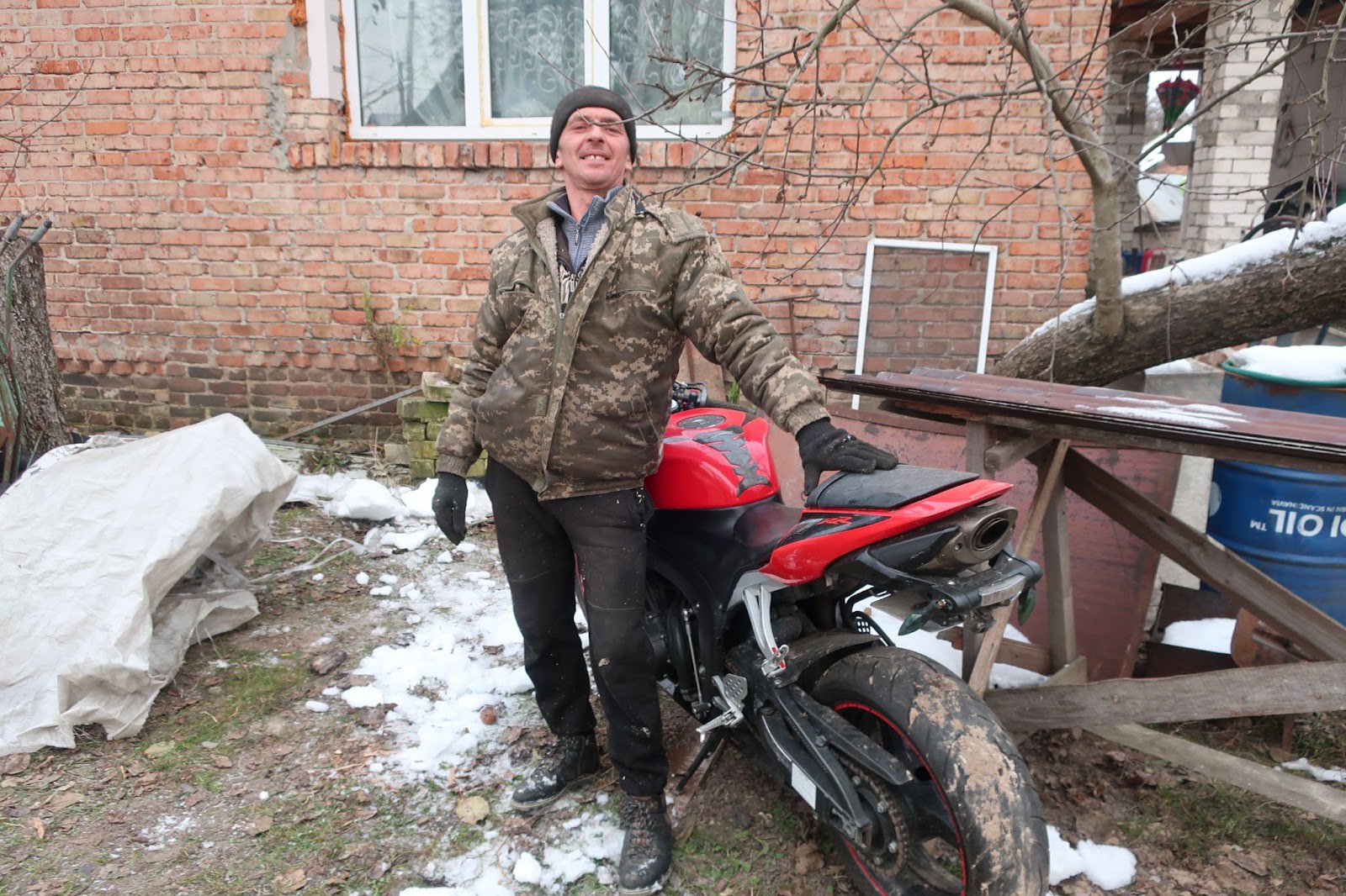Юрій Телень біля мотоцикла одного з оборонців, який вони зберігають у своєму дворі. Фото авторки
