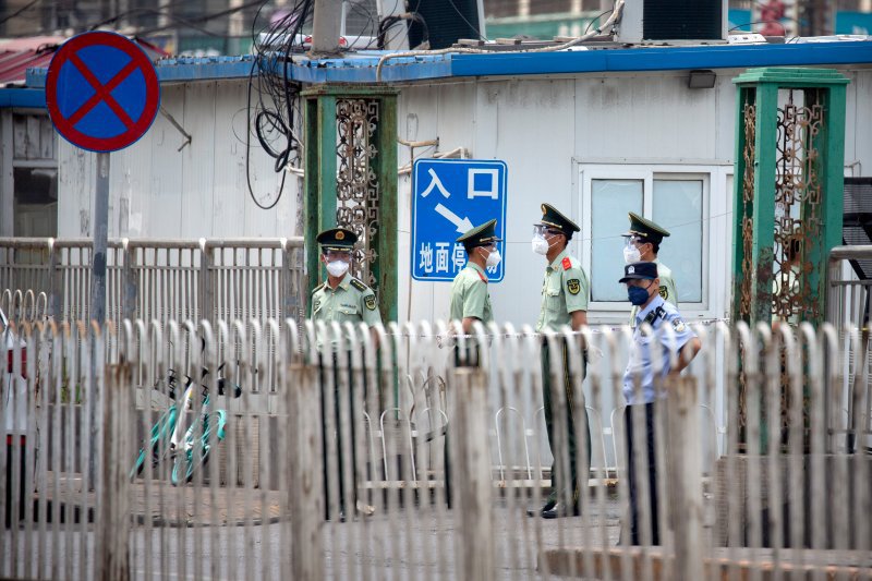 Поліція біля закритого ринку в Пекіні: фото Mark Schiefelbein/AP