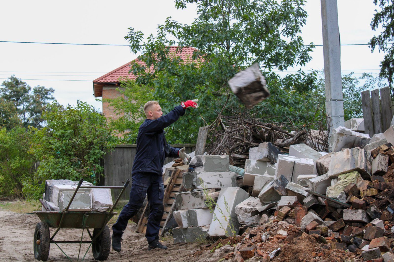 Волонтер розвантажує тачку з будівельними блоками. Фото авторки