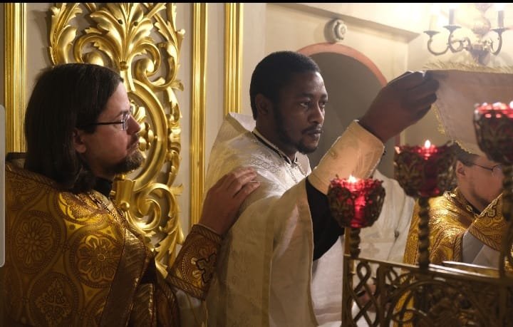 Daniel Agbaza, a Nigerian priest, at a service in Moscow. (Right)