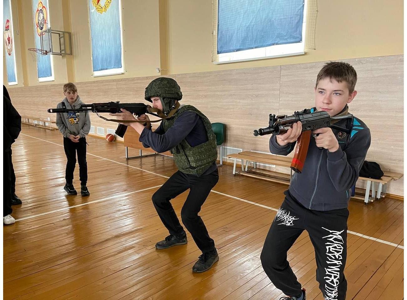 The 49th Radio Engineering Brigade practicing an AK shooting stance with children