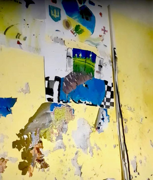 Залишки карти України та дитячих малюнків на посіченій уламками стіні в цокольному приміщенні